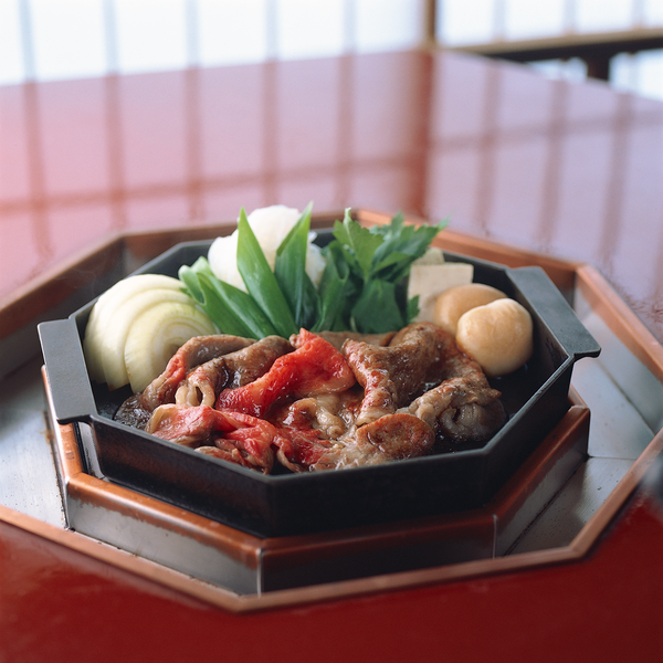 Action shot of sukiyaki being prepared tableside
